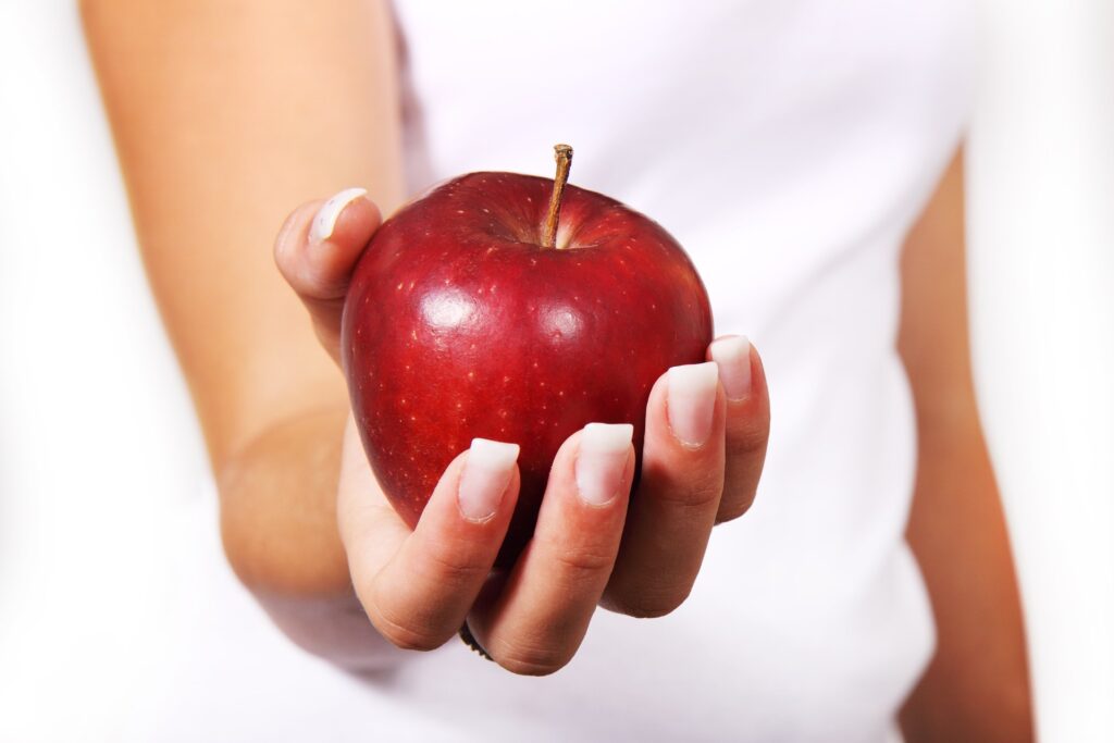 mão de mulher segurando uma maçã em destaque