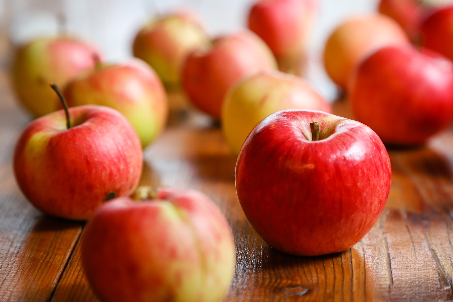 Várias maçãs sobre uma mesa de madeira - benefícios da maçã