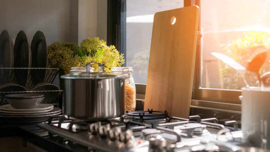 detalhe de um pôr-do-sol na janela de uma cozinha limpa e organizada