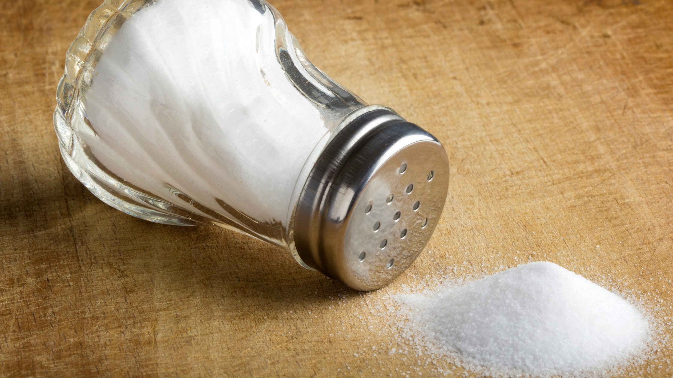 um vidrinho de sal sobre uma mesa para ilustrar dicas de como substituir o sal no dia a dia