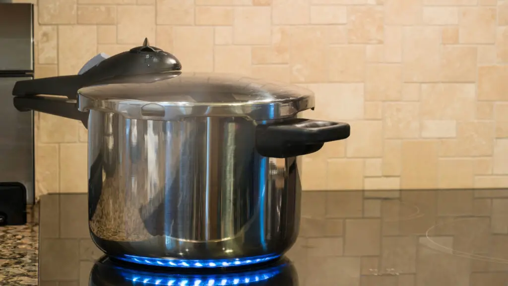 foto de uma panela de pressão em cima de cooktop de indução para ilustrar dicas de como usar panela de pressão com segurança