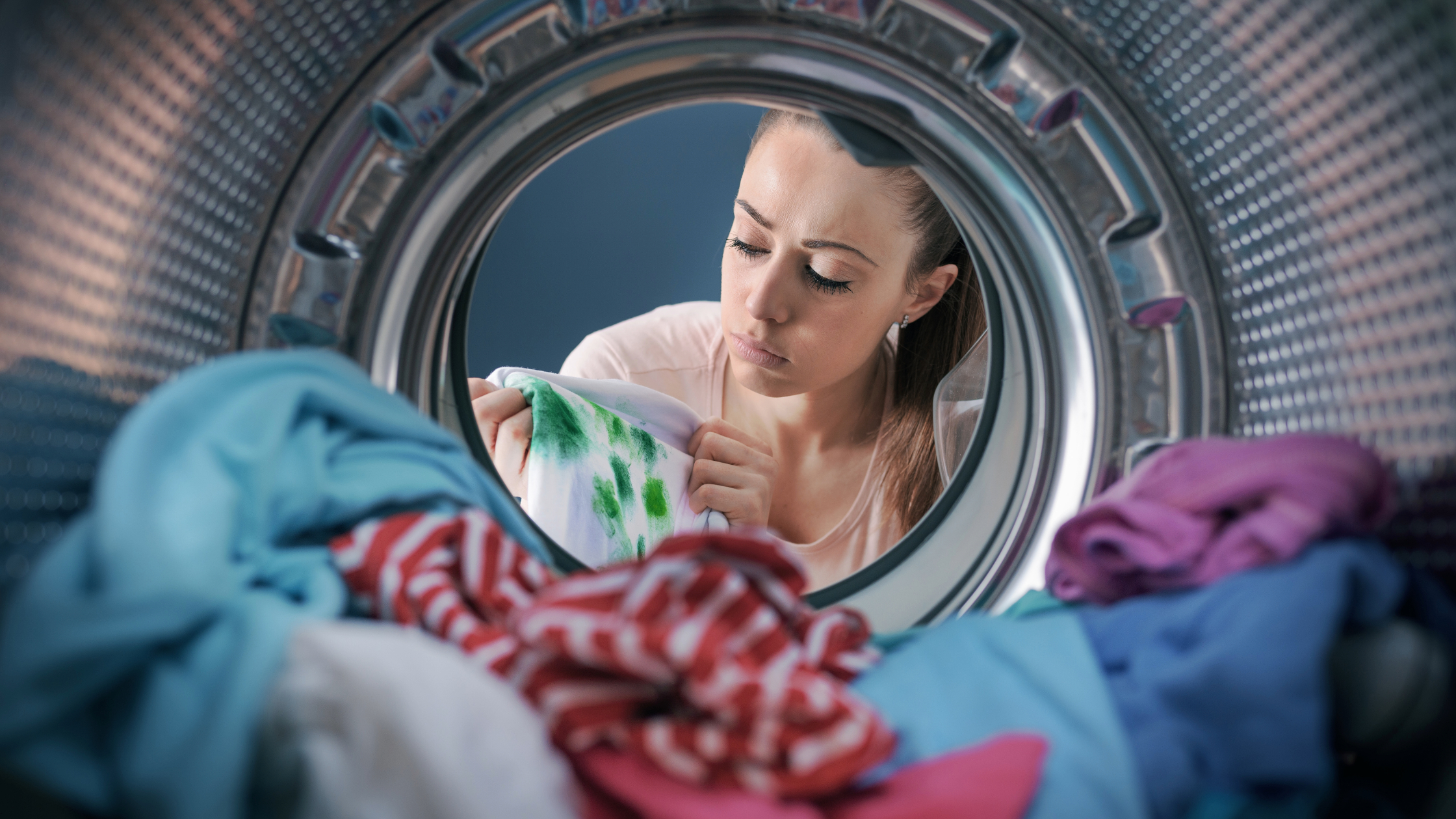 visão de dentro de uma máquina lava roupas de uma mulher pensando em como lavar pano de prato sujo